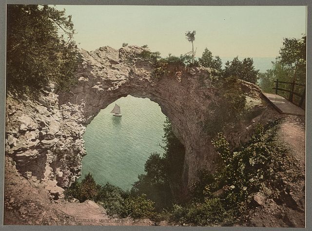 Arch Rock on Mackinac Island, a limestone arch above the trees, in a color print from 1899.